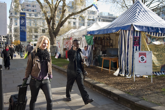 Passersby ignoring the music and video clips in the info tent