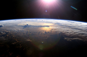Photo de l'Océan pacifique vue de l'espace : les nuages sont en relief vu la levée du soleil.