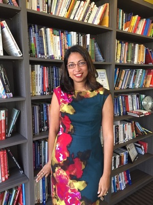 Fauzia Burke, author of Online Marketing for Busy Authors, standing in front of bookshelves 