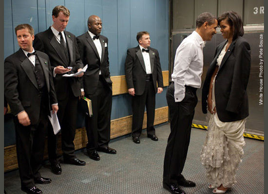 Mrs. Obama keeping warm in the President's jacket while riding on a freight elevator.