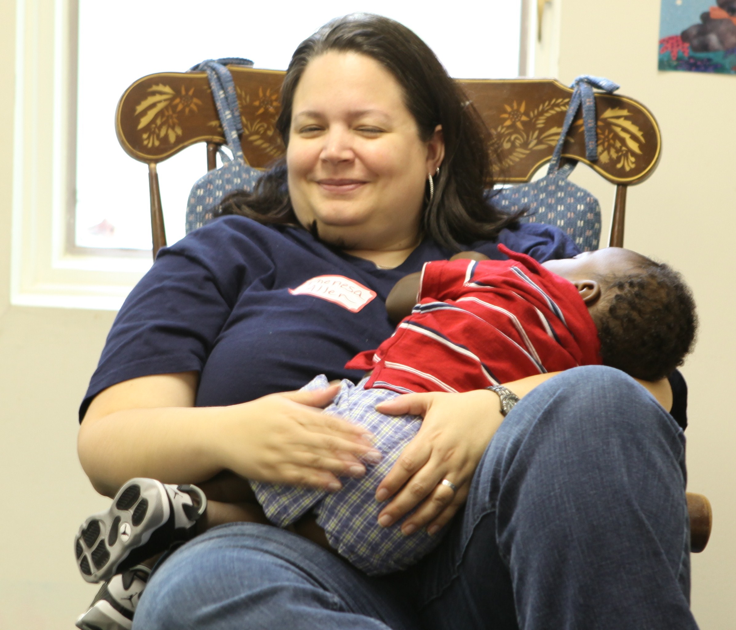 2012-07-02-VolunteerTheresaAllenrocksbabytosleep.jpg