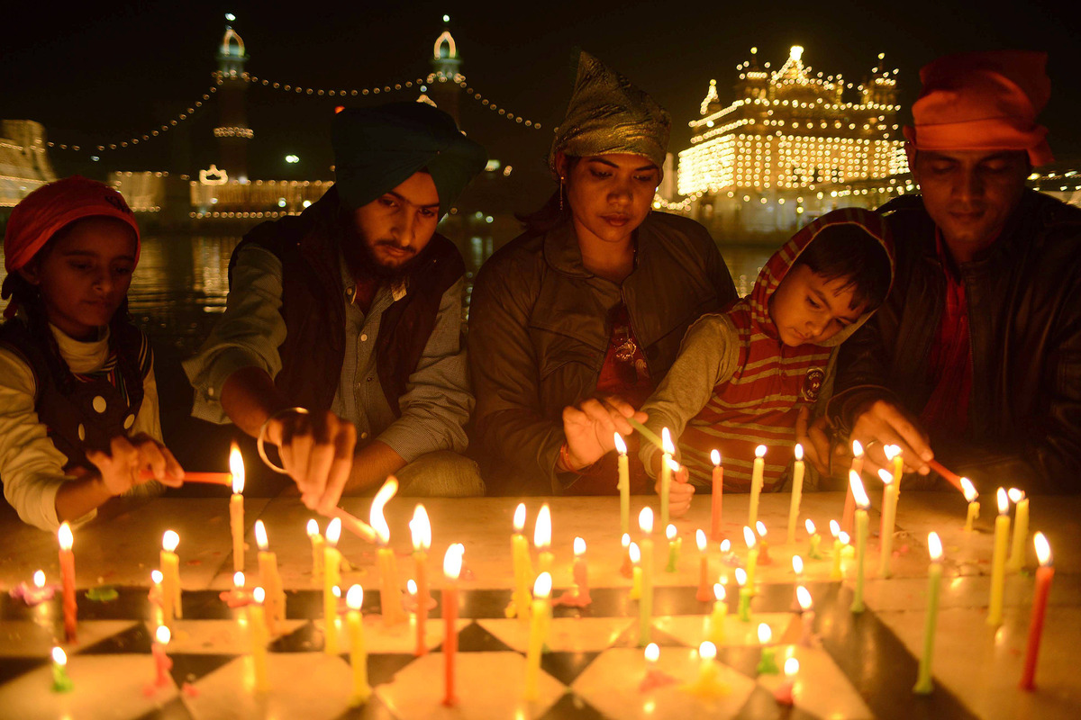 Indian Sikh devotees light candles as they pay their respects at the illuminated Sikhism's holiest shrine Golden Temple in Amritsar on November 12, 2012, on the eve of Bandi Chhor Divas or Diwali. Sikhs celebrate Bandi Chhor Divas or Diwali to mark the return of the Sixth Guru, Guru Hargobind Ji, who was freed from imprisonment and also managed to release 52 political prisoners at the same time from Gwalior fort by Mughal Emperor Jahangir in 1619. (NARINDER NANU - AFP/Getty Images)