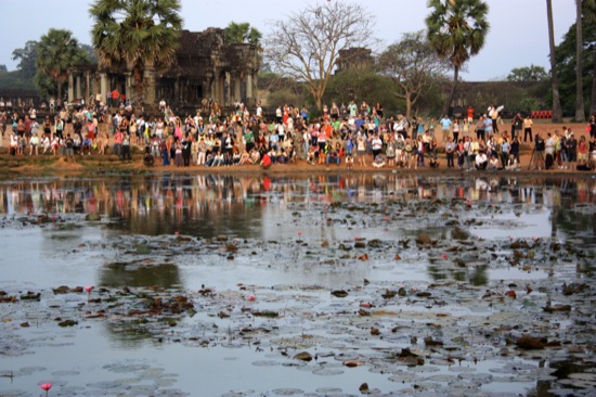 Crowd watches sunrise over Angkor Wat