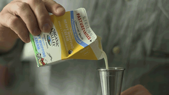 Jim Meehan measures heavy cream in a cocktail jigger