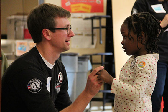 An AmeriCorps member talks with a child during the 2014 Martin Luther King Jr. Day of Service in Washington, D.C.