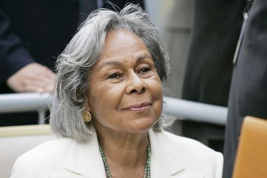 Party at Jackie Robinson's house: Rachel Robinson showing David Robinson  how to feed a baby with